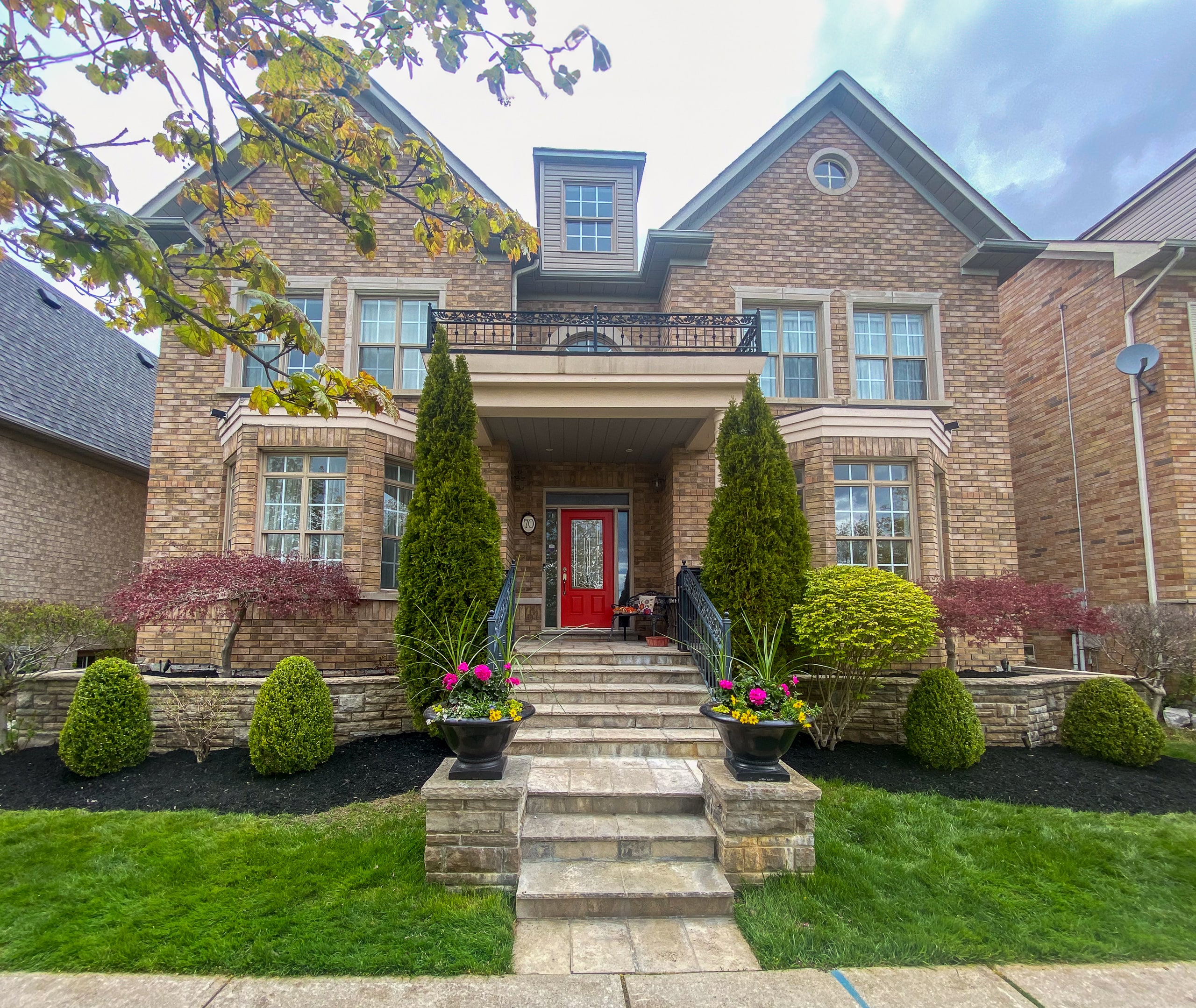 Front of home in the GTA with luxurious gardens and landscaping